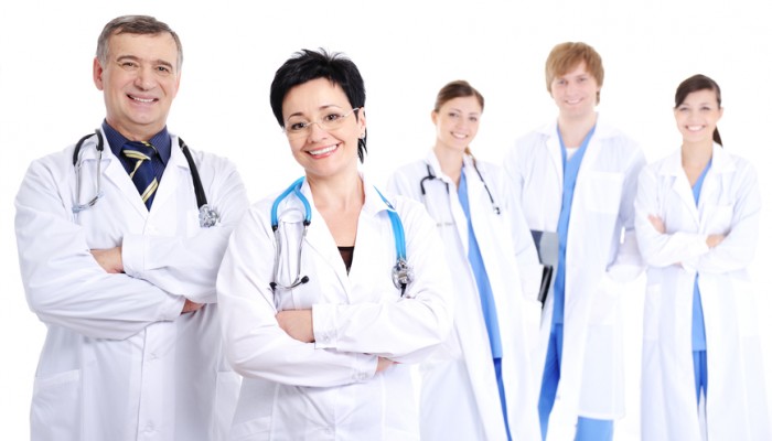 group of five happy smiling cheerful doctors in hospital gowns